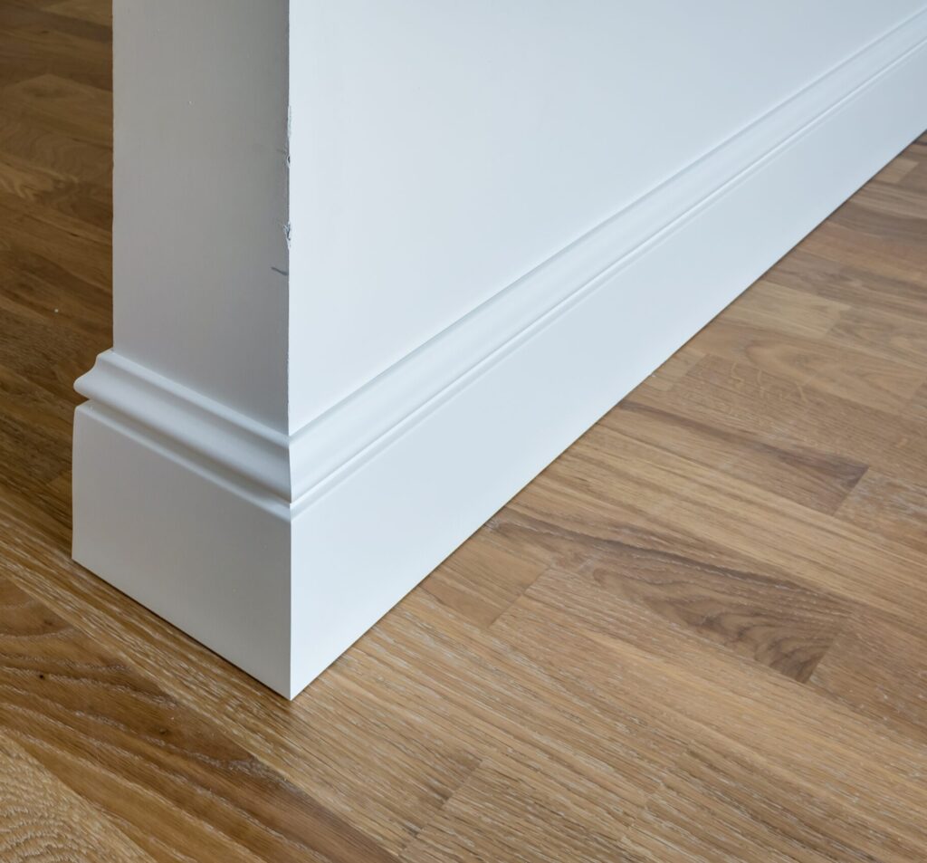 Detail of corner flooring with intricate crown molding and plinth.